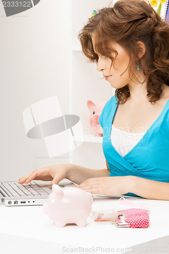 Image of lovely woman with piggy bank and money