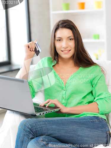 Image of happy woman with laptop computer and credit card