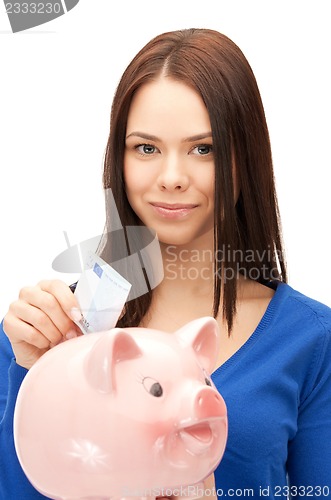 Image of lovely woman with piggy bank and money