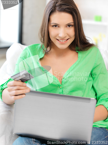 Image of happy woman with laptop computer and credit card