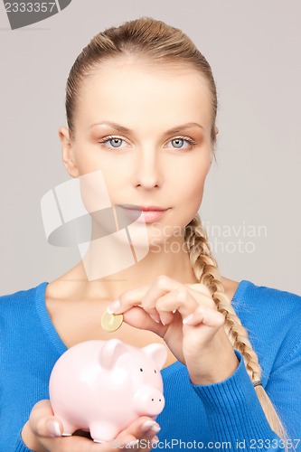 Image of lovely woman with piggy bank and money