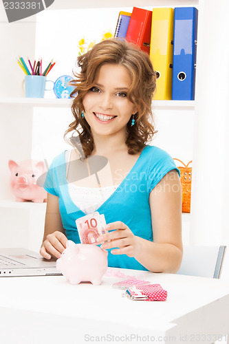 Image of lovely woman with piggy bank and money