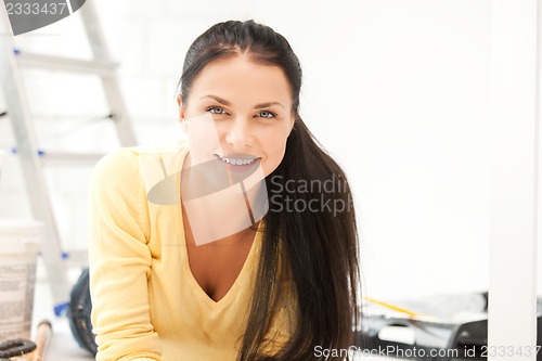 Image of lovely housewife making repairing works