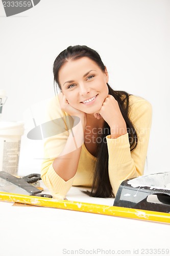 Image of lovely housewife making repairing works