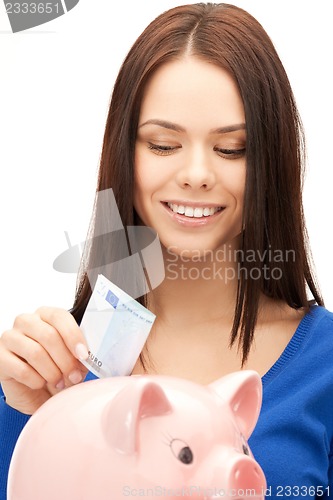 Image of lovely woman with piggy bank and money