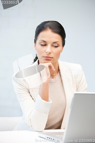 Image of pensive woman with laptop computer