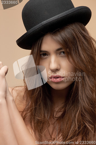 Image of beautiful topless woman in bowler hat