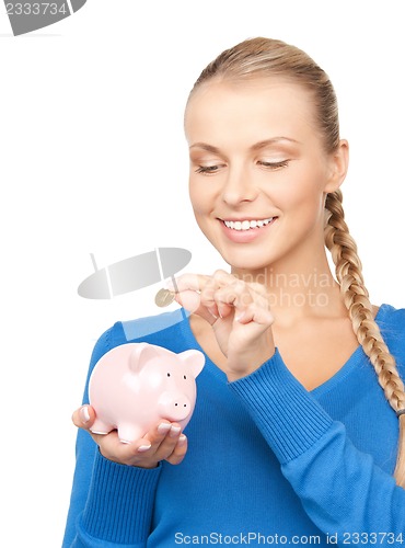 Image of lovely woman with piggy bank and money