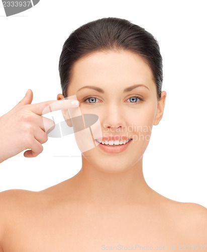 Image of beautiful woman pointing to eye