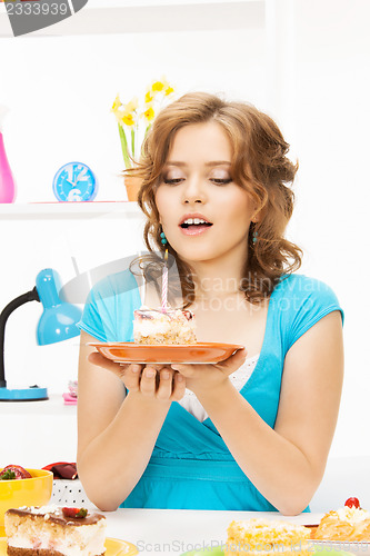 Image of lovely housewife with cake and candle