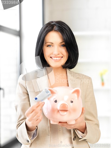 Image of lovely woman with piggy bank and money