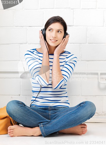Image of happy teenage girl in big headphones