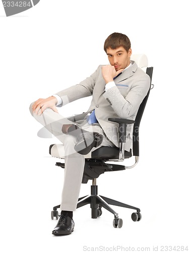 Image of young businessman sitting in chair