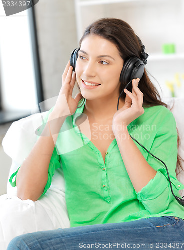 Image of happy teenage girl in big headphones