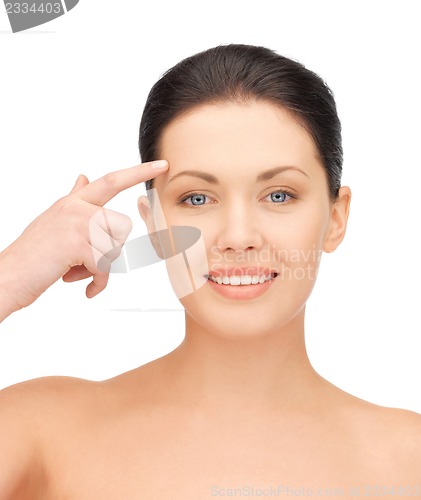 Image of beautiful woman pointing to forehead