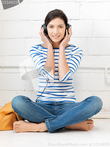 Image of happy teenage girl in big headphones