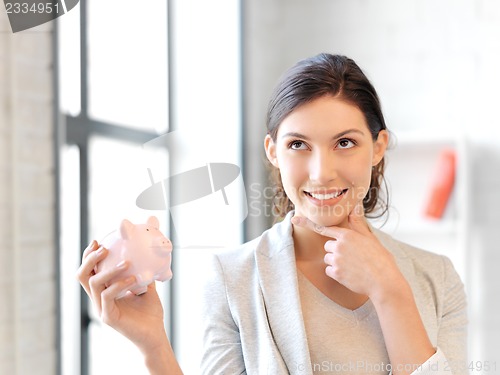 Image of lovely woman with piggy bank