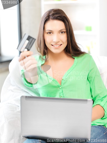 Image of happy woman with laptop computer and credit card