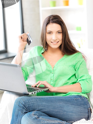 Image of happy woman with laptop computer and credit card