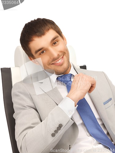 Image of young businessman sitting in chair