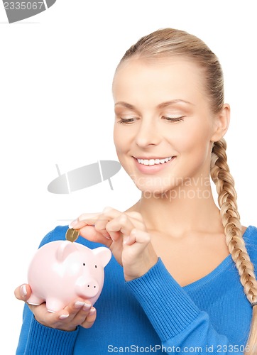 Image of lovely woman with piggy bank and money