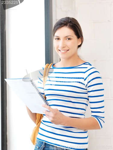 Image of happy and smiling teenage girl with big notepad