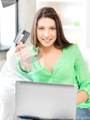 Image of happy woman with laptop computer and credit card