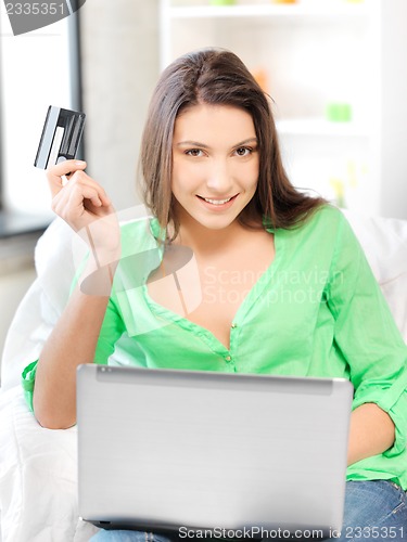 Image of happy woman with laptop computer and credit card