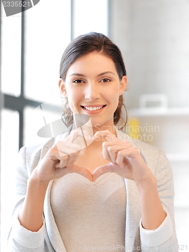Image of happy woman making heart gesture