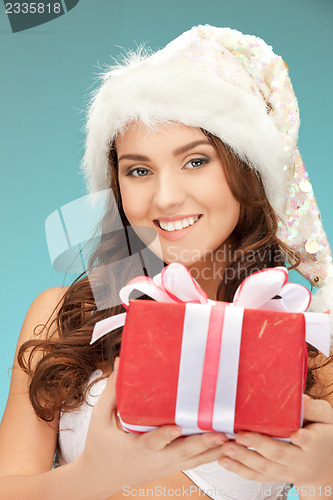 Image of cheerful santa helper girl with gift box