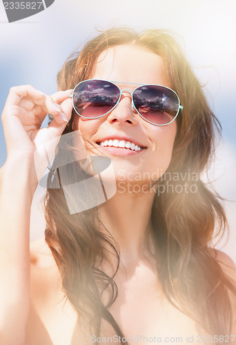 Image of beautiful woman in sunglasses on a beach
