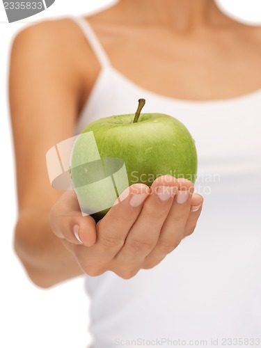 Image of female hands with green apple