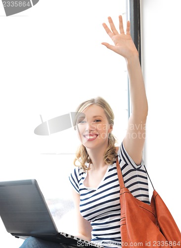 Image of happy teenage girl waving a greeting