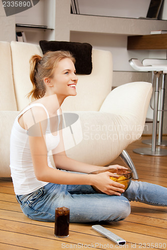 Image of smiling teenage girl with remote control