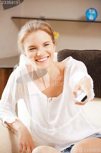 Image of happy teenage girl with TV remote