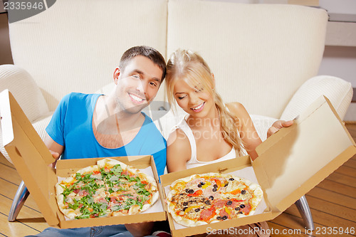 Image of romantic couple eating pizza at home