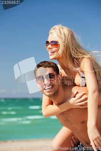 Image of happy couple in sunglasses on the beach