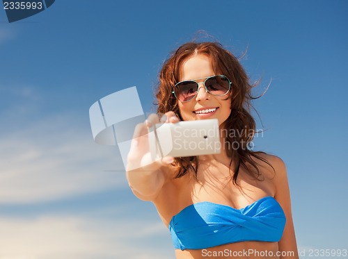 Image of happy woman with phone on the beach