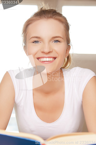 Image of happy and smiling teenage girl with book
