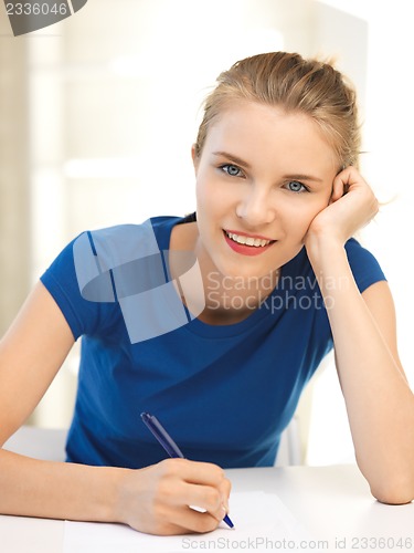 Image of happy teenage girl with pen and paper