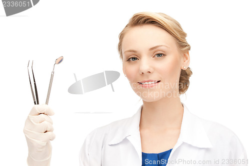 Image of attractive female dentist with tools