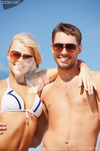 Image of happy couple in sunglasses on the beach