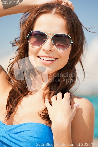 Image of beautiful woman in sunglasses on a beach
