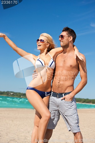 Image of happy couple in sunglasses on the beach