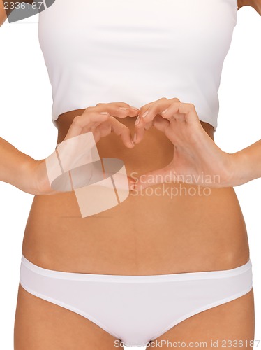 Image of woman forming heart shape on belly