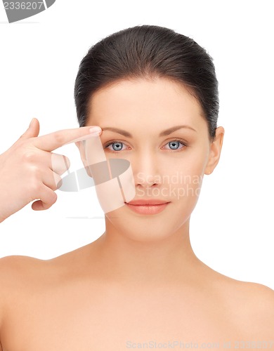 Image of beautiful woman pointing to forehead