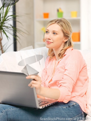 Image of happy woman with laptop computer and credit card