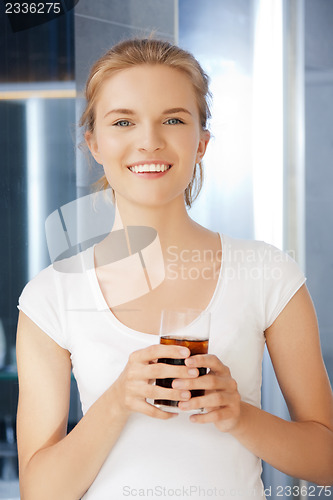 Image of happy and smiling teenage girl with glass of cola