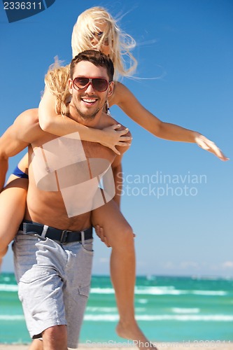 Image of happy couple in sunglasses on the beach