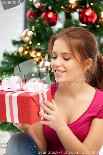 Image of happy woman with gift box and christmas tree